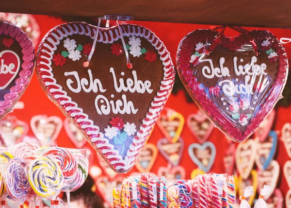 Gingerbread hearts cookies in Christmas Market at Gendarmenmarkt in Winter Berlin; Germany. Advent Fair Decoration and Stalls with Crafts Items on the Bazaar.