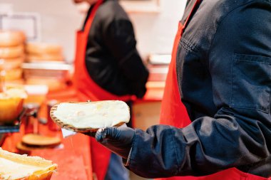 Winter Berlin, Almanya Gendarmenmarkt'ta Gece Noel Pazarı'nda raclette Peynirli tost ekmeği satan kişi.
