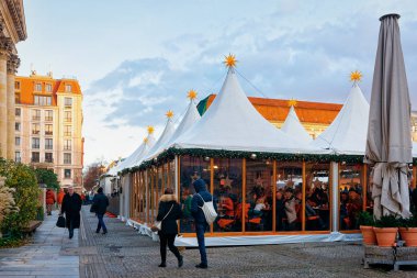 Berlin, Almanya - 8 Aralık 2017: Almanya'nın Kış Berlin kentinde Gendarmenmarkt'taki Gece Noel Pazarında yiyecek Tezgahları'nda insanlar. Advent Fuarı Dekorasyon ve El Sanatları Çarşısı'ndaki Ürünler.