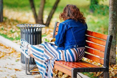 Rusya 'da Moskova' daki Novodevichy Gölü 'nde, Park' ta bankta oturan kadın.