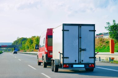 Asfalt yolun Slovenya römork taşıyan mini van.