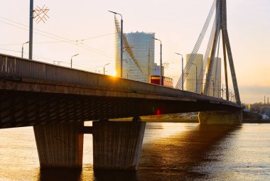 Modern iş gökdelenler ve Vansu Köprüsü Letonya Riga'da Daugava Nehri üzerinde. Akşam günbatımında