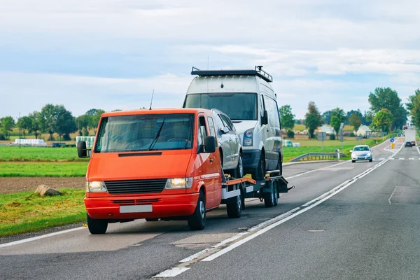 Car carrying trailer with mini vans on the asphalt road of Slovenia.