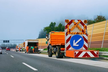 Sol yansıtıcı yön yol işareti aşağı ok otoyol Polonya taşıyan kamyon.