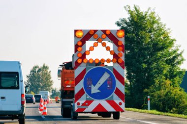 Sol yansıtıcı yön yol işareti aşağı ok karayolu Polonya taşıyan kamyon.