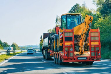 Kamyon römork ışınlama yolda, Slovenya tarım traktör taşıyan hauler ile.
