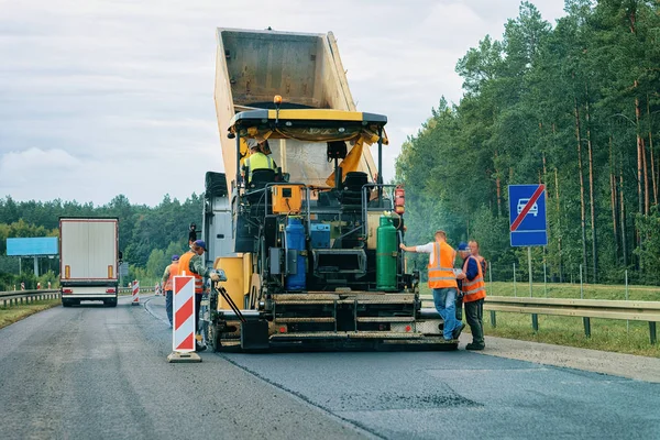 Polonya yolda yol kaldırım makine. İşçi finişer son işlemci.
