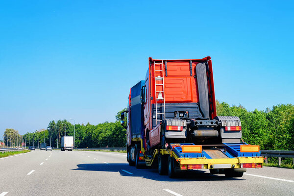 Truck transporter carrying lorry cabin in the highway road in Slovenia. Transport delivering some freight cargo.