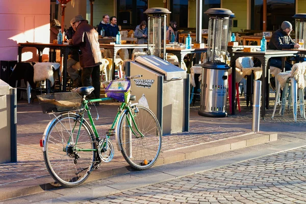 Kerékpár parkol és az emberek iszik utcai kávézóban Ljubljanában — Stock Fotó