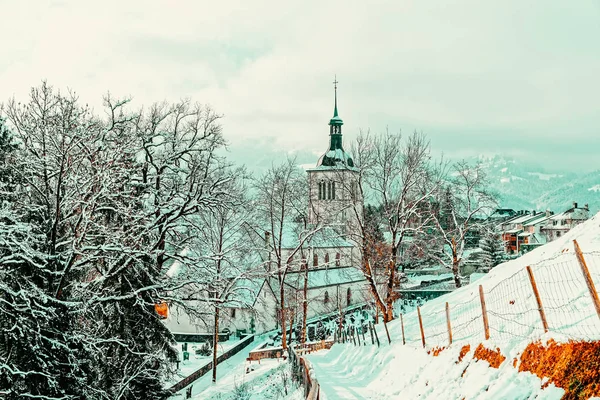 Kyrka med alpina berg av Gruyeres vinter — Stockfoto