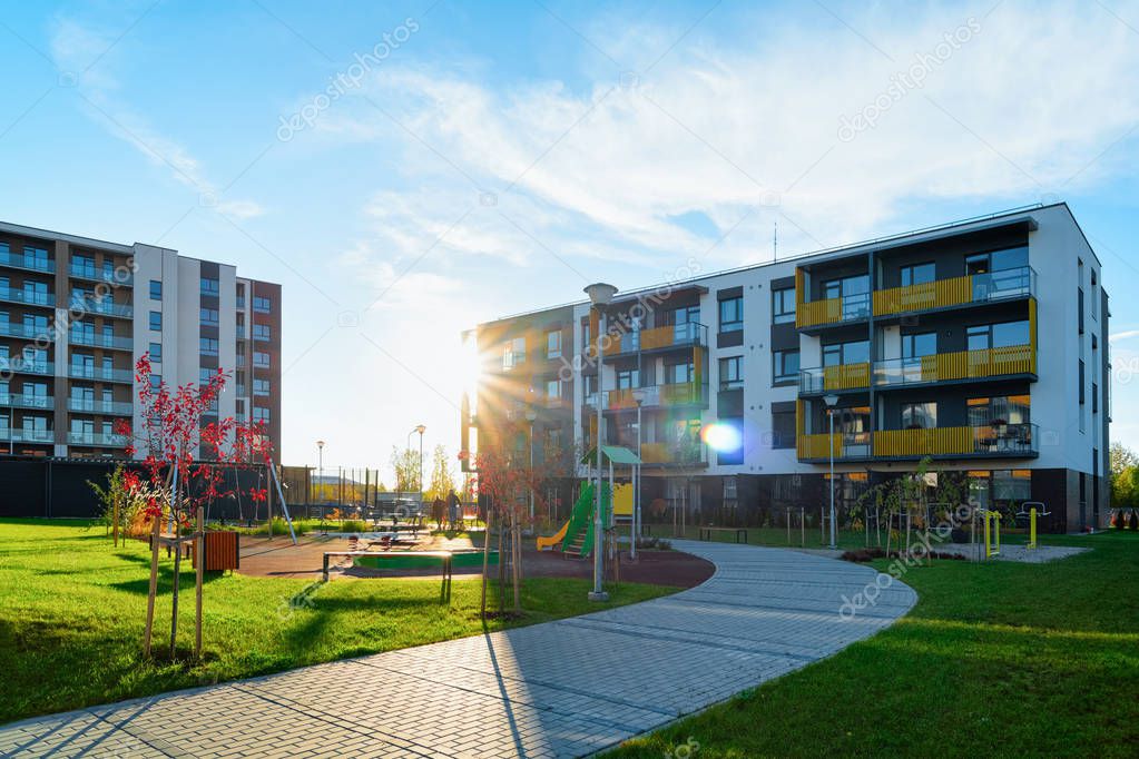 Apartment residential house facade architecture with kids playground sun light