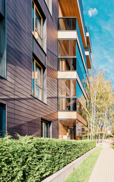 Современное стеклянное жилое здание и березы
