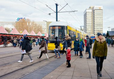 Şehir merkezinde Alexanderplatz sokakta İnsanlar ve sarı tramvay