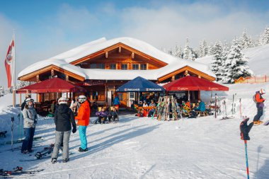 Zillertal Arena'da masaları olan sokak kafelerde insanlar