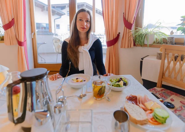 Mutlu gülümseyen kadın kahvaltı yapıyor