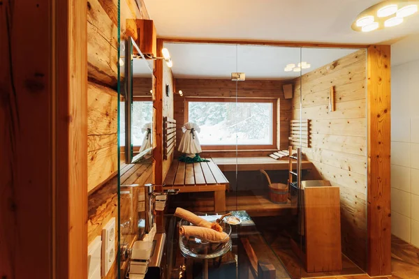 Интерьер в современной ванной комнате с деревянной сауной — стоковое фото