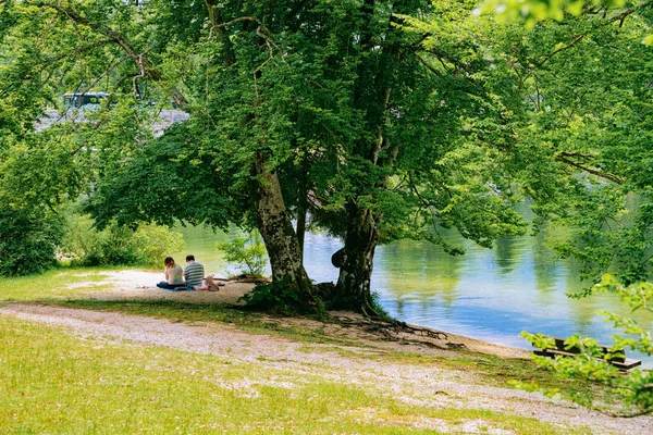 Personas sentadas y paisajes del lago Bohinj en Eslovenia — Foto de Stock