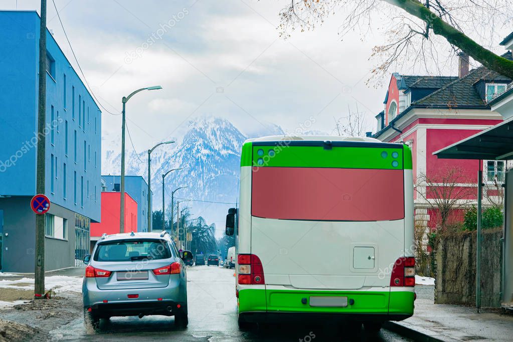 Car and back of shuttle bus on road in Salzburg