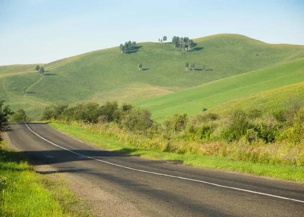 Empty Road and Nature in countryside with green hills