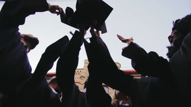 Aşağıdan sınırlarına hava atma ve onları yakalamak ve erkek mezunları üzerinde görüntüleyin. Çok etnik grup. Açık havada