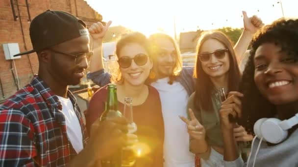 Mixed Races Freunde machen Selfies und posieren bei der Rooftop Party im Sonnenuntergang in die Kamera. Ziegelmauer und Himmelshintergrund. Stadtraum. Außenbereich. — Stockvideo