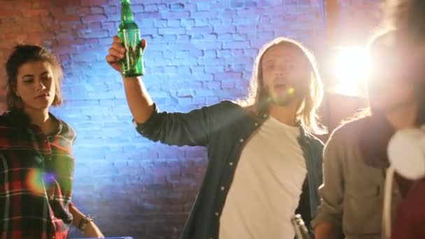 Close up of multiethnical young people drinking beerand doing cheers at the rooftop party at night. The brick wall background. Outside. — Stock Video