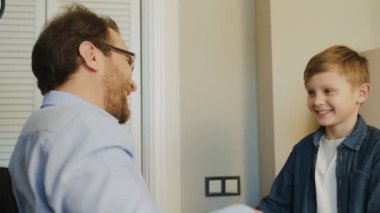 Gözlük ve sevimli sarışın oğlu evde beş birbirlerine veren yakışıklı baba. Gülümsüyor ve mutlu adam ve çocuk. İçinde