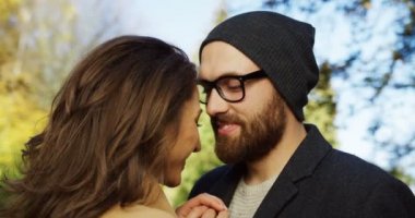 Diğer her ile gülümseyen ve şefkatle birbirlerine parkta seyir alınları, dokunmadan aşık genç romantik çiftin yakın çekim. erken sonbahar güneşli gün. Portre. Açık havada