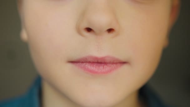 カメラの前で笑顔の子供たちの口閉じます。少年は、笑みを浮かべてします。中に — ストック動画