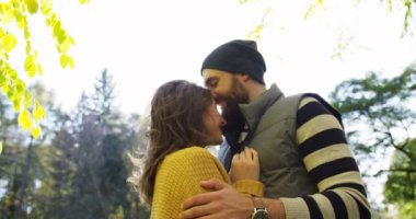 Portre çekim sarılma ve güneşli bir sonbahar park ortasında romantik çekici çift ayakta okşama. Açık havada