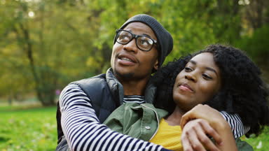 Aşk sarılma ve adam ilginç bir şey kadına söylüyor genç çekici Afrikalı-Amerikalı çiftin yakın çekim. Sonbahar pitoresk park. Açık. Portre vurdu