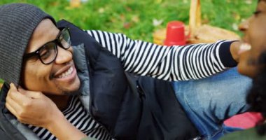 Çim üzerinde yalan ve birbirlerine sonbahar güzel parkta okşama aşk genç Sevimli Afrikalı-Amerikalı çiftin yakın çekim. Açık. Portre