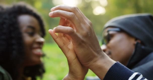 Närbild av håller händerna på afroamerikanska par i kärlek. Suddig bakgrund. Porträtt — Stockvideo