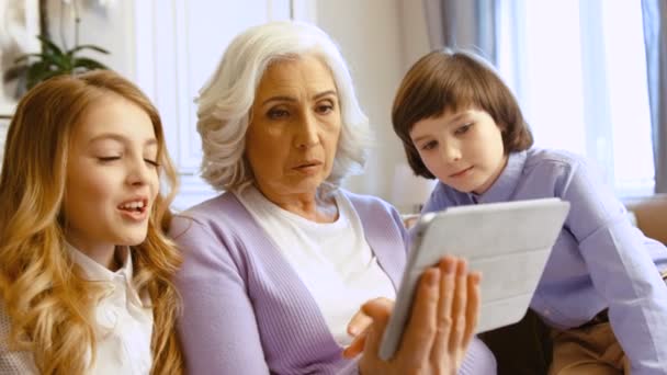 Mooie Grootmoeder Met Haar Kleinkinderen Met Behulp Van Tablet Voor — Stockvideo