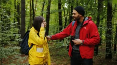 Genç sportif çift ormanın ortasında duruyor. Kadın yorgun ve having bir baş ağrısı. Dışarıda