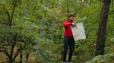 Genç sportif çalılıkları ormanın ortasında duran ve haritaya bakıyordum adamım. Ormanın derinliklerinde kaybolup uzun yürüyüşe çıkan kimse. Açık havada
