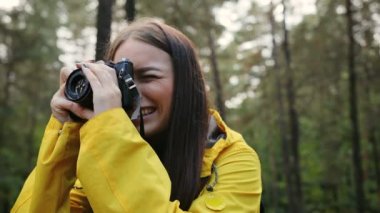 Vintage kameranın orman doğa fotoğrafını çekmek genç güzel kadın kapatın. Dışarıda. Portre vurdu