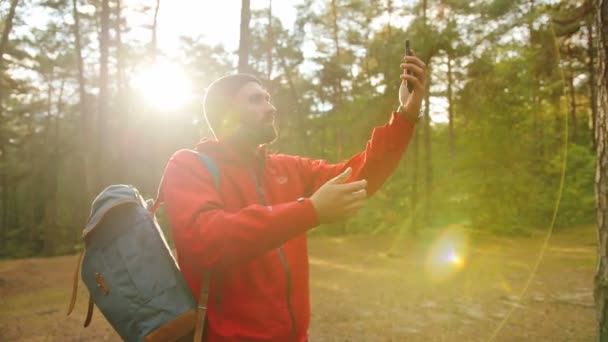 Jóvenes senderistas atractivos buscan la conexión móvil en el bosque en un día soleado. Me pierdo. Afuera. — Vídeo de stock