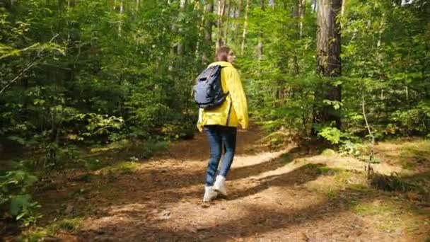 Parte trasera de la joven mujer bonita turista con la cámara de la vendimia senderismo solo en el hermoso bosque verde y dando la vuelta. Exterior — Vídeo de stock