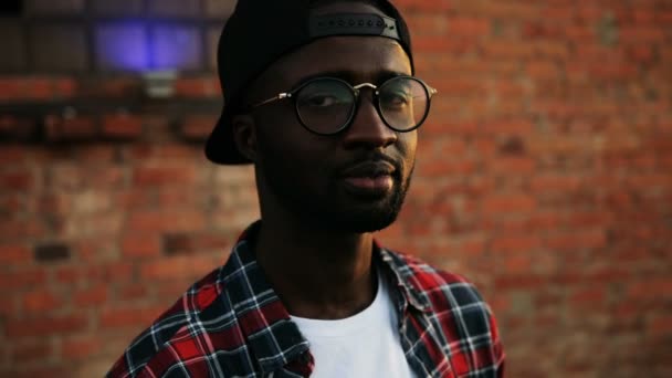 Close up of African American young man in sunglasess at the rooftop party. The brick wall background. Urban space. Outside. Portrait — Stock Video