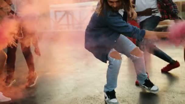 Grupo de jóvenes bailando con granada de humo rosa en la fiesta de la azotea en el espacio urbano. El fondo del atardecer. Afuera. Multi-étnico — Vídeos de Stock