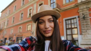 Selfie ile Smartphone cep telefonu ile fotoğraf makinesi alarak güzel kız portresi. Güzel evin arka plan üzerinde Antik şehrin merkezinde duran genç kadın.