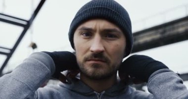 Onun kaputa alarak ve kamerayı düz yumruk başlayan kızgın erkek boksör kapatın. Atılan kat kentsel gri bulutlu sabahleyin mahveder. Portre vurdu