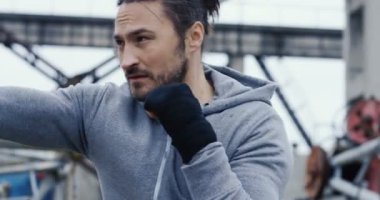 Beyaz genç boksör havada soğuk bulutlu günde tekme için eğitim. Dışarıda. yakın çekim. Portre vurdu