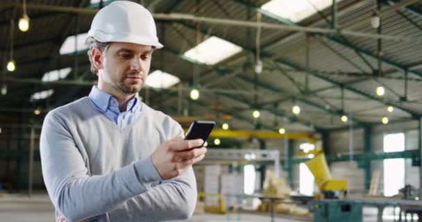 Retrato Hombre Guapo Ingeniero Casco Grabando Desplazándose Teléfono Inteligente Gran — Vídeo de stock