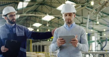 Kayıt ve fabrika işçisi, sallayarak erkekler gelmeye bir kask içinde verdiğinde onun tablet üzerinde kaydırma ve ne onlar fabrikada bir tablet ekranda görmek tartışırken bir kask içinde yakışıklı mühendisi