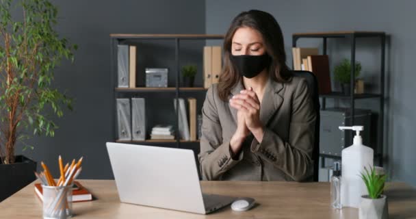 Femme d'affaires caucasienne masquée assise à table et pulvérisant un désinfectant sur les mains au bureau. Protection contre le coronavirus. Nettoyage, stérilisation et désinfection des femmes. Femme travaillant sur ordinateur portable. — Video