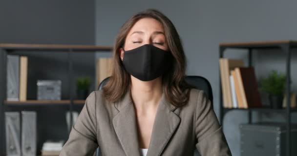 Gros plan de Caucasien beau jeune blogueur d'affaires en masque assis dans le bureau et parler à la caméra. Femme d'affaires expliquant les affaires et l'enseignement en ligne. Femme qui blogue sur la quarantaine. — Video