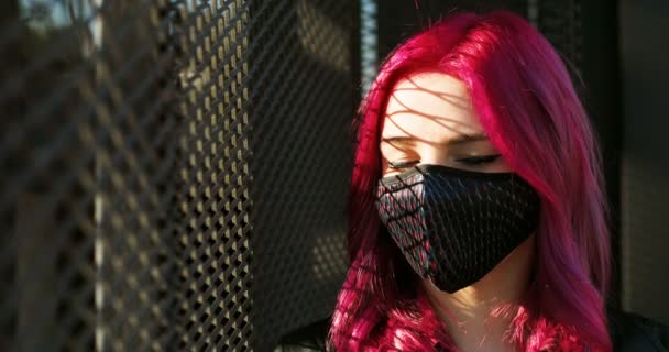 검정 마스크를 쓰고 얼굴을 카메라로 돌리는 아름다운 코카서스 소녀의 초상화. 코로나 바이러스가 있는 동안 호흡기 보호 분야에서 비범 한 여성의 근접 사진 촬영. — 비디오
