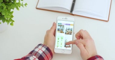 New York - 15 Mayıs 2020: beyaz akıllı telefon, Pinterest uygulamasını kullanan ve içerideki fotoğraflara bakan beyaz kadının elinde. Kadın telefon dinlemesi ve kaydırma yapıyor. Tasarım konsepti.